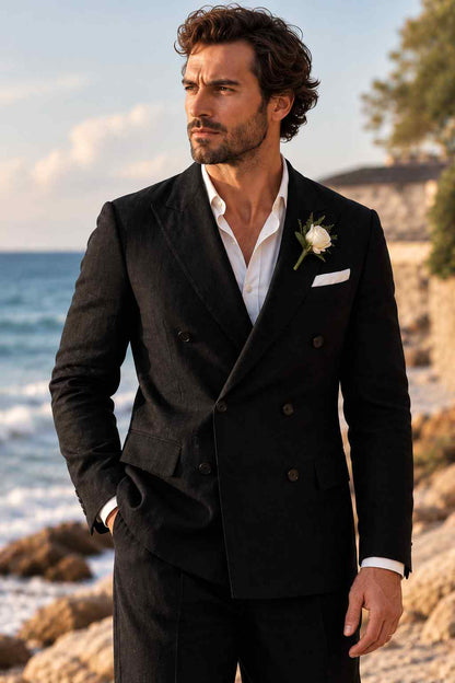 Man wearing a black double-breasted 2-piece suit with wide lapels, white shirt, white pocket square, and rose boutonniere.
