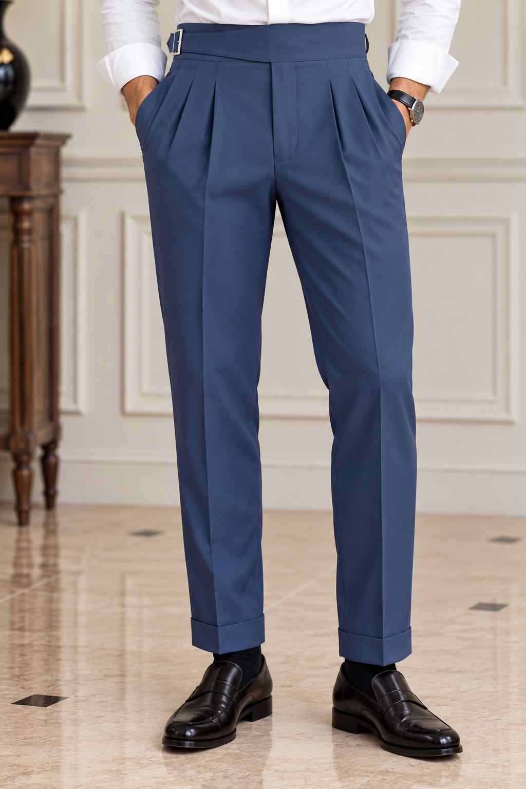 Men's navy blue high-waisted Gurkha trousers featuring double front pleats, adjustable side buckles and turn-up cuffs.