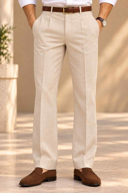 Men’s cream pleated trousers with tailored straight-leg fit, belt loops, side pockets, and brown loafers.